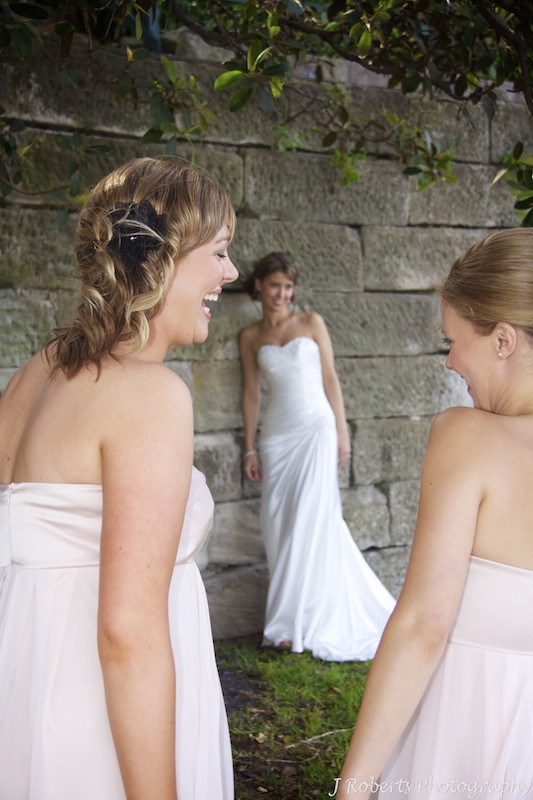Bridesmaids laughing with bride in background - wedding photography